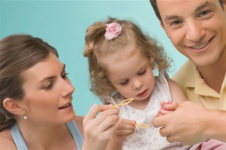 simsearch:625-02929316,k - Close-up of a mid adult couple playing with their daughter Stock Photo - Premium Royalty-Free, Code: 625-02267337