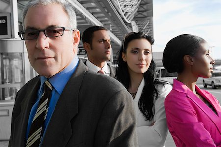 simsearch:625-02931717,k - Two businessmen standing at an airport with two businesswomen Stock Photo - Premium Royalty-Free, Code: 625-02267457