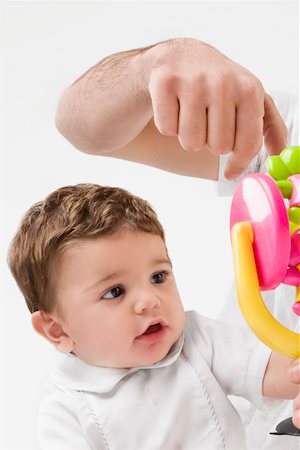 simsearch:625-02929316,k - Close-up of a person's hand holding a toy in front of a baby boy Stock Photo - Premium Royalty-Free, Code: 625-02267511