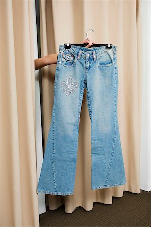 Person's hand showing a jeans through curtains Stock Photo - Premium Royalty-Free, Code: 625-02267555