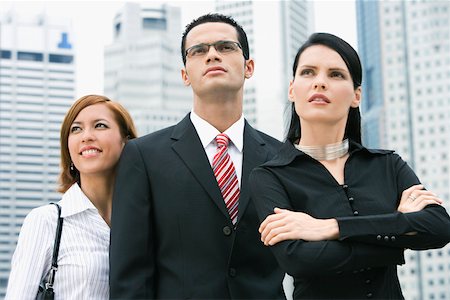 shirt collar - Close-up of a businessman standing with two businesswomen Foto de stock - Sin royalties Premium, Código: 625-02267635