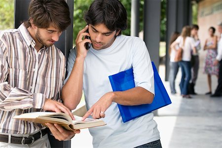 simsearch:614-06973867,k - Deux jeunes hommes regardant un livre dans un couloir Photographie de stock - Premium Libres de Droits, Code: 625-02267682