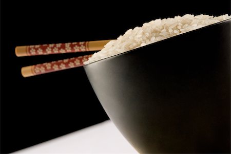Close-up of white rice and chopsticks in a bowl Stock Photo - Premium Royalty-Free, Code: 625-02927441