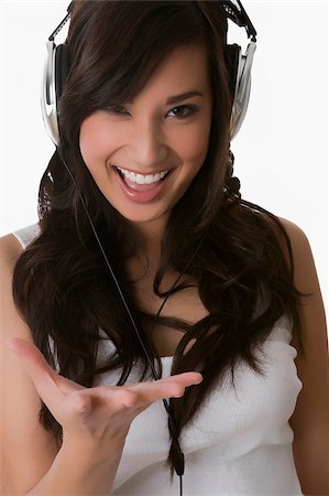 Portrait of a young woman listening to music with headphones and laughing Stock Photo - Premium Royalty-Free, Code: 625-02929036