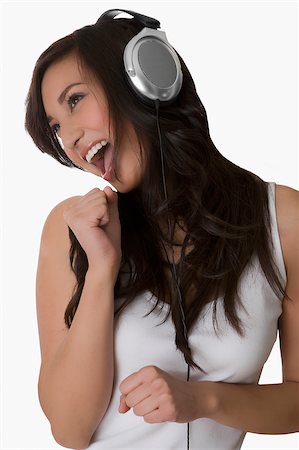 Close-up of a young woman listening to music with headphones and laughing Stock Photo - Premium Royalty-Free, Code: 625-02929037