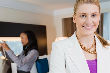 simsearch:625-02931998,k - Portrait of a businesswoman smiling with another businesswoman standing in the background Stock Photo - Premium Royalty-Free, Code: 625-02929343