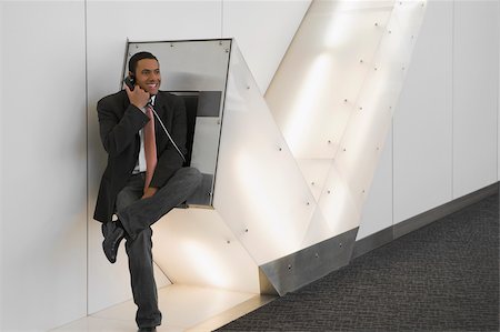 simsearch:625-02929600,k - Businessman talking on a pay phone at an airport and smiling Stock Photo - Premium Royalty-Free, Code: 625-02929627