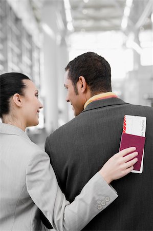 simsearch:625-02929600,k - Rear view of a businesswoman and a businessman looking at each other at an airport Stock Photo - Premium Royalty-Free, Code: 625-02929654