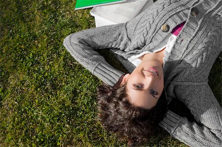 Portrait of a young woman lying in a lawn Stock Photo - Premium Royalty-Free, Code: 625-02929676
