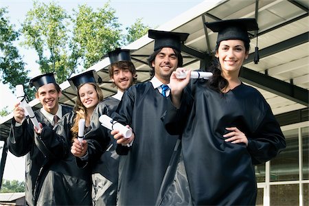 Portrait of graduate students holding their degrees and smiling Stock Photo - Premium Royalty-Free, Code: 625-02929844