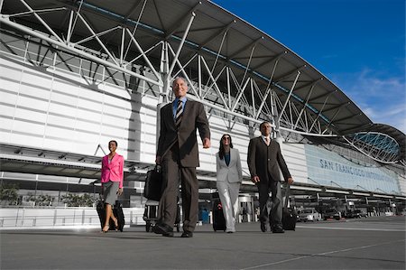simsearch:625-02929600,k - Two businessmen with two businesswomen walking outside at an airport Stock Photo - Premium Royalty-Free, Code: 625-02929945