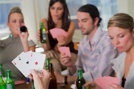 Young man with her friends playing cards Stock Photo - Premium Royalty-Free, Code: 625-02930216