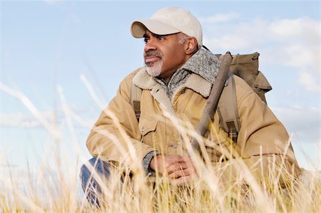 Mature man sitting and holding a stick Stock Photo - Premium Royalty-Free, Code: 625-02930253