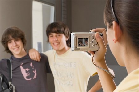 Close-up of a teenage girl taking a photograph of her two friends with a digital camera Stock Photo - Premium Royalty-Free, Code: 625-02930338