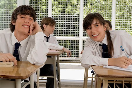 Teenage girl and a young man sitting in a classroom and smiling Stock Photo - Premium Royalty-Free, Code: 625-02930341