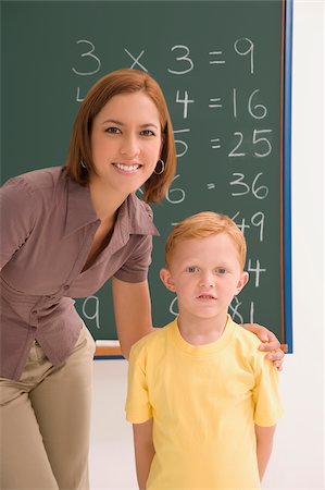 Portrait of a schoolboy standing with his female teacher in a classroom Stock Photo - Premium Royalty-Free, Code: 625-02930458