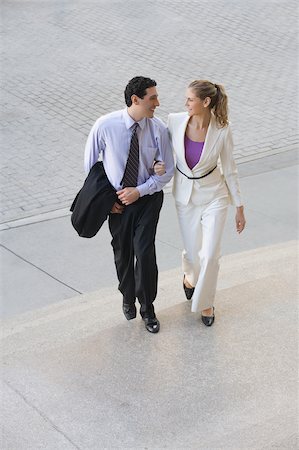 simsearch:625-02931998,k - Businessman and a businesswoman moving up on steps with their arm in arm Stock Photo - Premium Royalty-Free, Code: 625-02930840