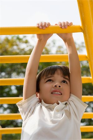 simsearch:625-02929316,k - Low angle view of a boy hanging on monkey bars Stock Photo - Premium Royalty-Free, Code: 625-02930908