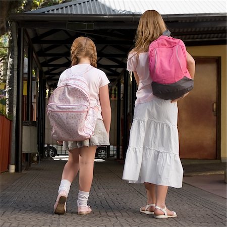 pictures of braids for a 12 year old girl - Rear view of two schoolgirls carrying schoolbags and walking Stock Photo - Premium Royalty-Free, Code: 625-02930935