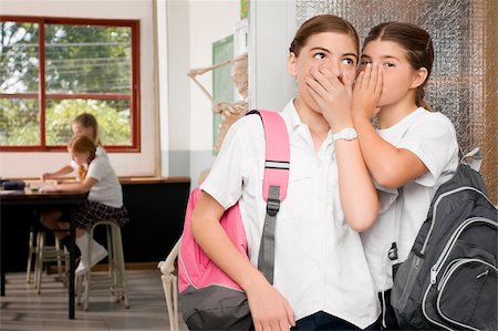 Close-up of a schoolgirl whispering to another schoolgirl Stock Photo - Premium Royalty-Free, Code: 625-02930950