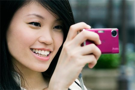 Close-up of a young woman taking a picture with a digital camera Stock Photo - Premium Royalty-Free, Code: 625-02931123