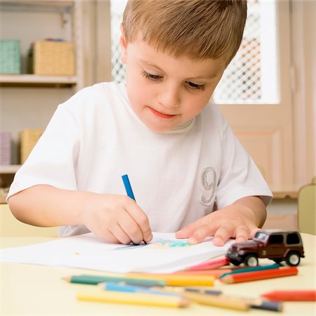 Close-up of a boy drawing on a sheet of paper Stock Photo - Premium Royalty-Free, Code: 625-02931597