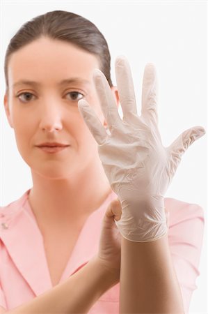 simsearch:625-02929180,k - Female nurse putting on a surgical glove Stock Photo - Premium Royalty-Free, Code: 625-02931730