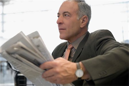 simsearch:625-02931717,k - Side profile of a businessman sitting at an airport and holding a newspaper Stock Photo - Premium Royalty-Free, Code: 625-02931933