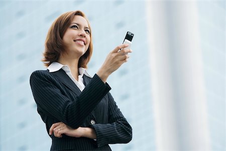 simsearch:625-02931998,k - Close-up of a businesswoman holding a mobile phone and smiling Stock Photo - Premium Royalty-Free, Code: 625-02932001