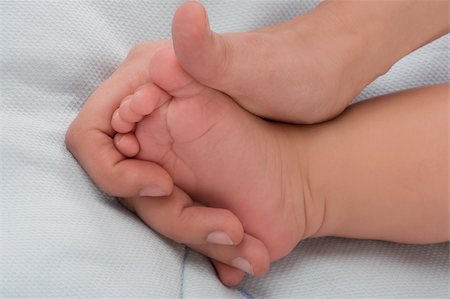 Close-up of a woman's hand holding a baby's foot Stock Photo - Premium Royalty-Free, Code: 625-02932127