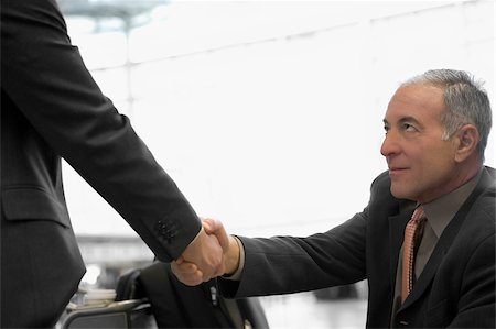 simsearch:625-02929600,k - Two businessmen shaking hands at an airport Stock Photo - Premium Royalty-Free, Code: 625-02932423