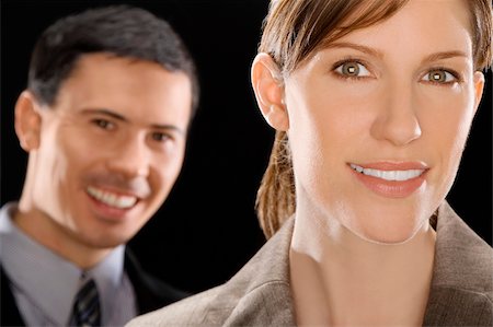 Portrait of a businesswoman smiling with a businessman behind her Stock Photo - Premium Royalty-Free, Code: 625-02932481