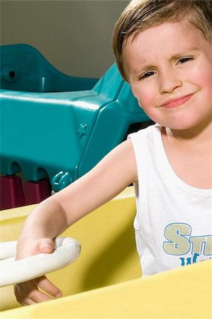 Portrait of a boy in a toy car Stock Photo - Premium Royalty-Free, Code: 625-02932553