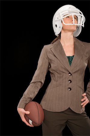 Businesswoman holding an American football and thinking Stock Photo - Premium Royalty-Free, Code: 625-02932668