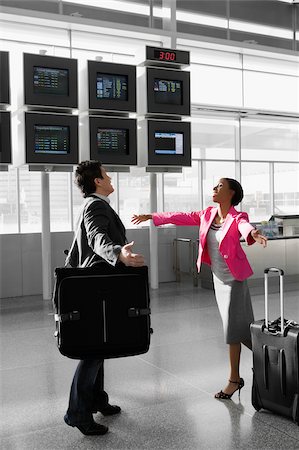 Businessman and a businesswoman walking at an airport to hug each other Stock Photo - Premium Royalty-Free, Code: 625-02932761