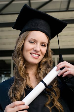 Portrait of a graduate student holding a diploma and smiling Stock Photo - Premium Royalty-Free, Code: 625-02932860