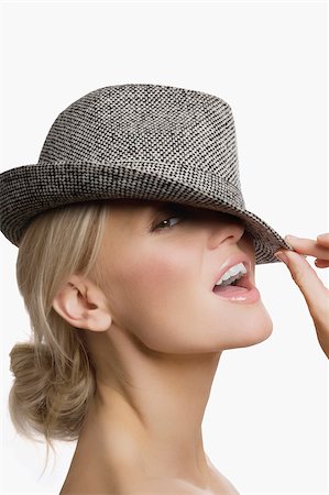 Portrait of a young woman wearing a hat and smiling Stock Photo - Premium Royalty-Free, Code: 625-02932978