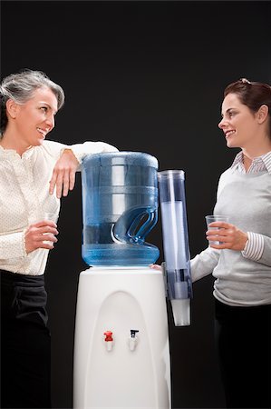 simsearch:625-02931998,k - Two businesswomen gossiping near a water cooler Stock Photo - Premium Royalty-Free, Code: 625-02933235
