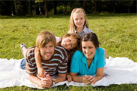 Happy family lying on blanket in grass, Munich, Bavaria, Germany Stock Photo - Premium Royalty-Free, Code: 628-05817219