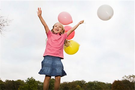 Happy girl holding balloons, Munich, Bavaria, Germany Stock Photo - Premium Royalty-Free, Code: 628-05817249