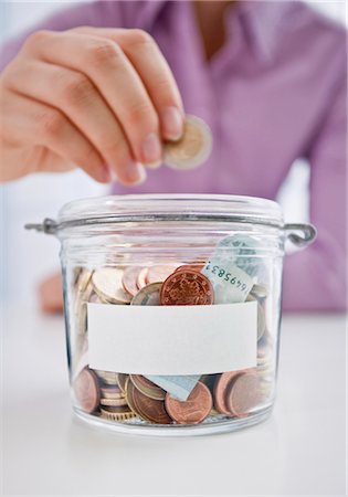 sticker - Woman is putting coin into savings box Stock Photo - Premium Royalty-Free, Code: 628-05817467