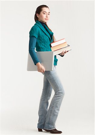Young woman holding laptop and books Stock Photo - Premium Royalty-Free, Code: 628-05817677