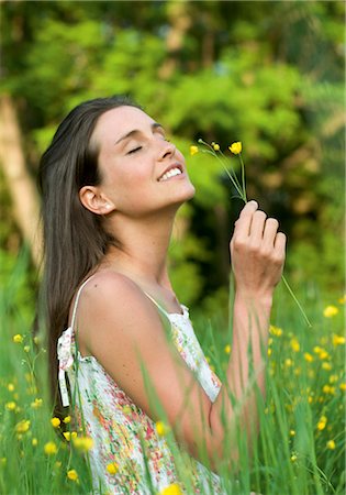 Woman in meadow smelling at flowers Stock Photo - Premium Royalty-Free, Code: 628-05817936