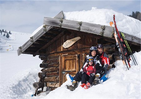 Family in front of a snow-covered alpine hut Stock Photo - Premium Royalty-Free, Code: 628-05818030