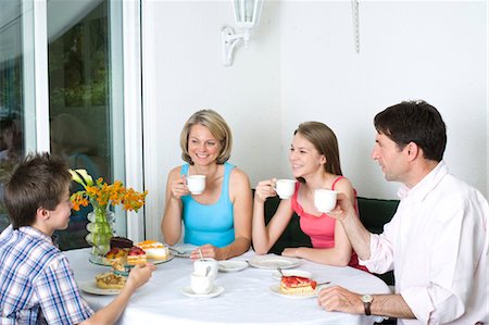 Family drinking coffee and eating cake on terrace, Munich, Bavaria, Germany Stock Photo - Premium Royalty-Free, Code: 628-05818106