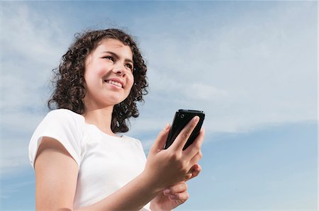 simsearch:628-07072097,k - Smiling girl outdoors holding cell phone Stock Photo - Premium Royalty-Free, Code: 628-07072106