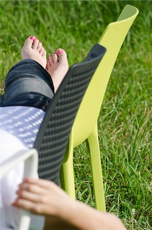 foot on chair - Female with painted toenails on plastic chair in meadow Stock Photo - Premium Royalty-Free, Code: 628-07072126