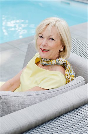 senior woman pool - Smiling senior woman sitting on couch by the poolside Stock Photo - Premium Royalty-Free, Code: 628-07072167