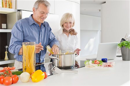 Senior couple preparing healthy pasta meal in kitchen Stock Photo - Premium Royalty-Free, Code: 628-07072162