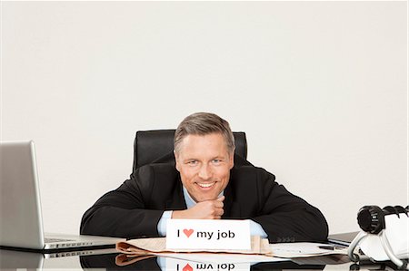 english (people) - Smiling manager sitting at desk Stock Photo - Premium Royalty-Free, Code: 628-07072215